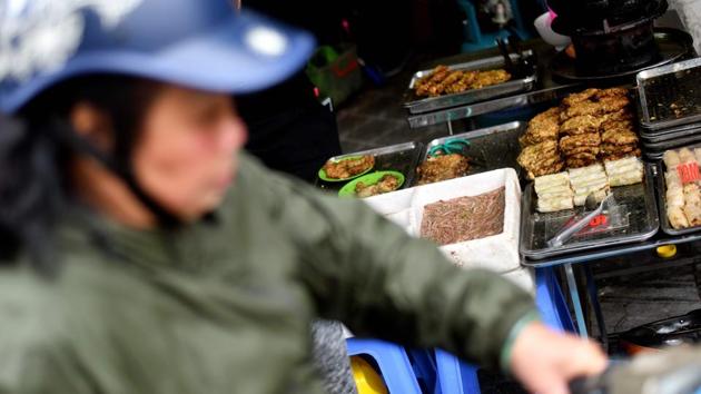 A woman rides past a street food stall selling ‘cha ruoi’ ragworms fritters. Back in Hanoi the worm fritters will no doubt remain a cold-weather staple. “I like eating cha ruoi in the winter. You’ve got the sweet and sour flavour from the dipping sauce, and the herbs are cooling... it is very unique,” Hoang Thi Thu Hang told AFP. (Manan Vatsyayana / AFP) A woman rides past a street food stall selling ‘cha ruoi’ ragworms fritters. Back in Hanoi the worm fritters will no doubt remain a cold-weather staple. “I like eating cha ruoi in the winter. You’ve got the sweet and sour flavour from the dipping sauce, and the herbs are cooling... it is very unique,” Hoang Thi Thu Hang told AFP. (Manan Vatsyayana / AFP)