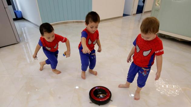 An Zhizhong, An Zhifei and An Zhiya play with a cleaning robot at their father An Hui’s office in Shenzhen. China moved in 2016 to allow couples to have a second child, relaxing curbs dating back nearly four decades. State media said this year the government was considering scrapping all limits on the number of children a family can have. (Jason Lee / REUTERS) An Zhizhong, An Zhifei and An Zhiya play with a cleaning robot at their father An Hui’s office in Shenzhen. China moved in 2016 to allow couples to have a second child, relaxing curbs dating back nearly four decades. State media said this year the government was considering scrapping all limits on the number of children a family can have. (Jason Lee / REUTERS)