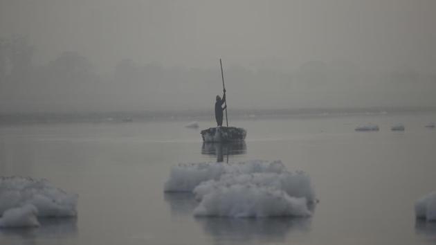 A man rows his boat on a foggy winter morning, at Kalindi Kunj, in New Delhi. (Burhaan Kinu / HT Photo)