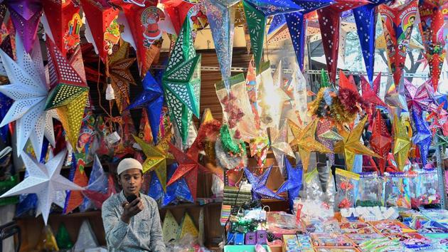 A young shopper sits amid decorative stars on display on a road side stall in Bengaluru, Karnataka, ahead of Christmas celebrations. (Manjunath Kiran / AFP)