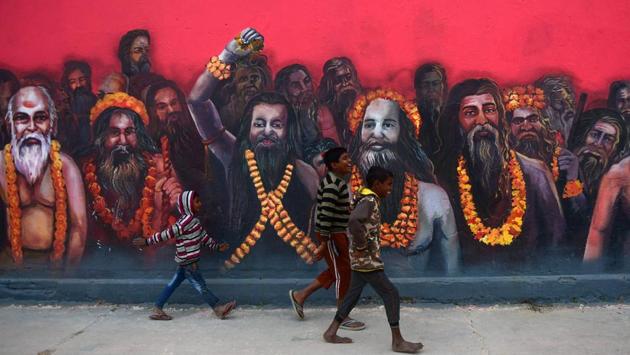 Children walk past a mural of sadhus on the wall of a temple, created as part of the ongoing ‘Paint My City’ project for the upcoming Kumbh Mela festival, in Prayagraj, Uttar Pradesh. (Sanjay Kanojia / AFP)