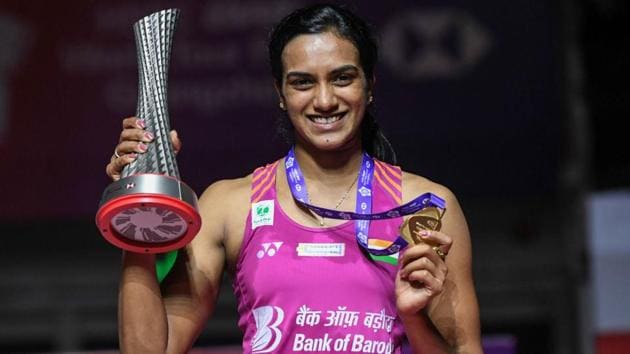 PV Sindhu poses with the trophy after the women's singles final match at the 2018 BWF World Tour Finals badminton competition.(AFP)