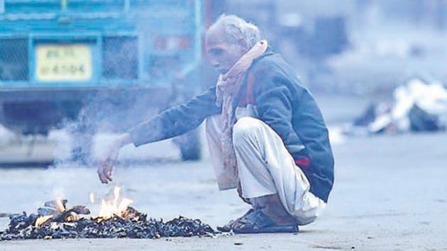 A man warms himself during cold winter morning, at Karol Bagh in New Delhi, India, (HT File) A man warms himself during cold winter morning, at Karol Bagh in New Delhi, India, (HT File)