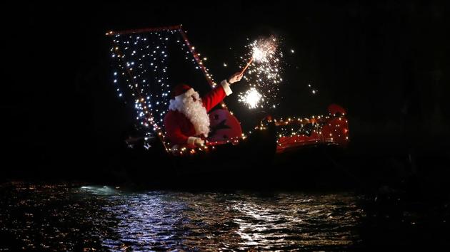 A festive spirit marked Christmas celebrations across the world with thousands of people visiting churches and offering prayers with some last-minute shopping thrown in the mix. Seen here is a man dressed as Santa Claus holding a flare on a boat during Christmas Eve celebrations in Imperia, Italy. (Antonio Calanni / AP photo) A festive spirit marked Christmas celebrations across the world with thousands of people visiting churches and offering prayers with some last-minute shopping thrown in the mix. Seen here is a man dressed as Santa Claus holding a flare on a boat during Christmas Eve celebrations in Imperia, Italy. (Antonio Calanni / AP photo)