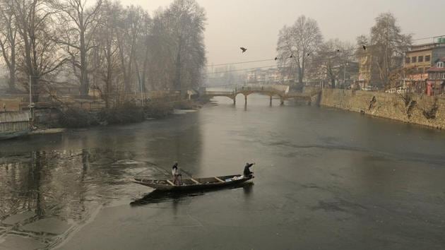 A boatman makes his way through partially frozen water of Dal Lake on a cold morning in Srinagar, Jammu and Kashmir. (Photo by Waseem Andrabi/ Hindustan Times)(HT Photo)