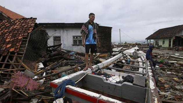 Sumur: A villager stands at a tsunami-ravaged village in Sumur, Indonesia, Tuesday, Dec. 25, 2018. The Christmas holiday was somber with prayers for tsunami victims in the Indonesian region hit by waves that struck without warning Saturday night. (AP) Sumur: A villager stands at a tsunami-ravaged village in Sumur, Indonesia, Tuesday, Dec. 25, 2018. The Christmas holiday was somber with prayers for tsunami victims in the Indonesian region hit by waves that struck without warning Saturday night. (AP)