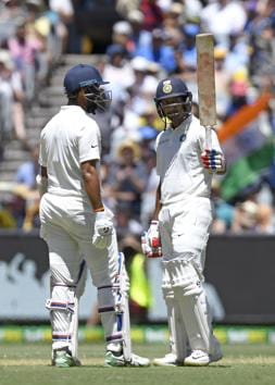 India's Mayank Agarwal, right celebrates with team mate, left Cheteshwar Pujara after scoring a half century on day one of the third cricket test between India and Australia in Melbourne. (AP)