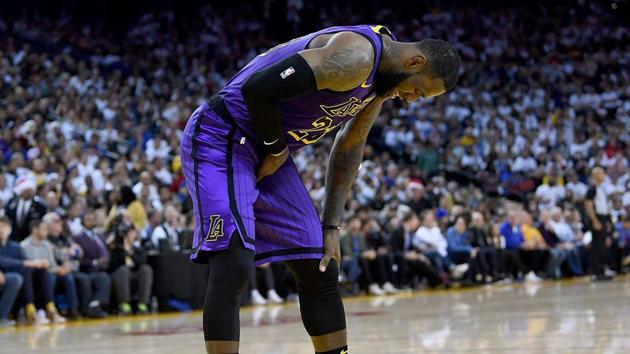 LeBron James #23 of the Los Angeles Lakers leans over in pain after he was hurt against the Golden State Warriors during the second half of their NBA Basketball game at ORACLE Arena.(AFP)