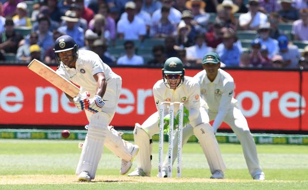 India's Mayank Agarwal (L) plays a shot as Australia's Tim Paine (C) and Usman Khawaja look on during day one of the third test match between Australia and India at the MCG in Melbourne. (REUTERS)