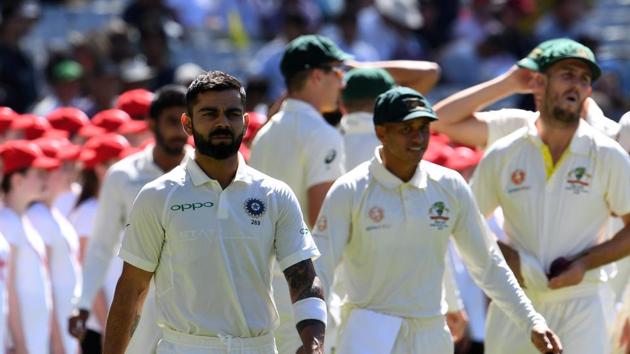 India's captain Virat Kohli (C) walks into the ground prior to play of day first of the third Test cricket match between Australia and India in Melbourne. (AFP)