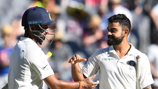 India's batsman Virat Kohli (R) greets his teammate Cheteshwar Pujara at the end of play on the day one of the third cricket Test match between Australia and India in Melbourne.(AFP)