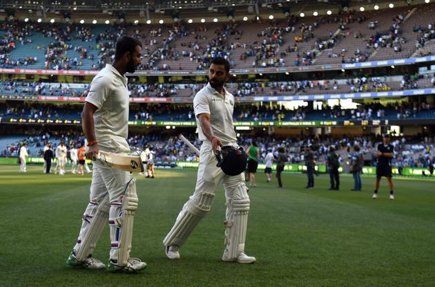 India's batsmen Virat Kohli (R) and Cheteshwar Pujara walk back to the pavilion at the end of play on the day one of the third cricket Test match between Australia and India in Melbourne . (AFP)
