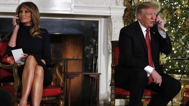 President Donald Trump and first lady Melania Trump both speak on the phone while sharing updates to track Santa's movements. (AP photo) President Donald Trump and first lady Melania Trump both speak on the phone while sharing updates to track Santa's movements. (AP photo)