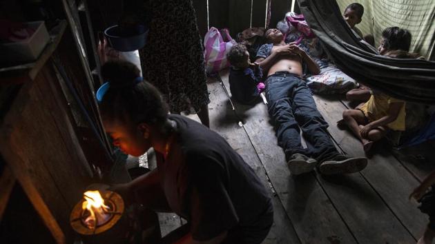 Paralysed by decompression sickness in 2017, Charles “Charly” Melendez, 28, stares at the ceiling lying on the floorboards of a rented room surrounded by his children. Safe standard diving techniques call for a gradual ascent to the surface to eliminate the nitrogen that the body absorbs. But many Mosquitia divers go deep, surface quickly and then go back for more, racing to collect as much lobster as possible. (Rodrigo Abd / AP)