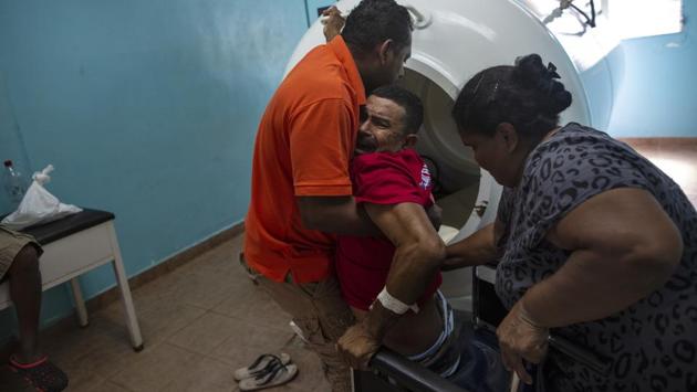 Lobster diver Misael Banegas Diaz, 49, paralysed by decompression sickness is lifted by physical therapist Cedrak Waldan Mendoza into a hyperbaric chamber at the hospital in Puerto Lempira, Honduras. With more than 60% of its 9 million people living in poverty, Honduras is one of the poorest countries in Latin America, and the Mosquitia one of the most impoverished areas. (Rodrigo Abd / AP)