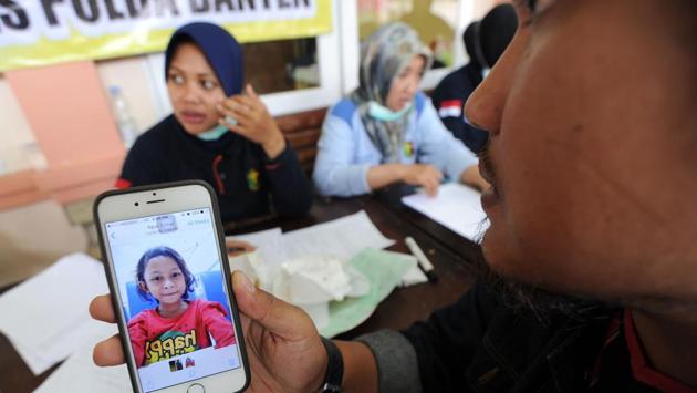 An Indonesian relative shows a picture from a phone to an officer at an identification centre in Pandeglang, Banten province. Arifin Hadi, head of disaster management at the Indonesian Red Cross said that their teams are seeing many broken bones and broken homes, and people who are very shaken. (Sonny Tumbelaka / AFP) An Indonesian relative shows a picture from a phone to an officer at an identification centre in Pandeglang, Banten province. Arifin Hadi, head of disaster management at the Indonesian Red Cross said that their teams are seeing many broken bones and broken homes, and people who are very shaken. (Sonny Tumbelaka / AFP)
