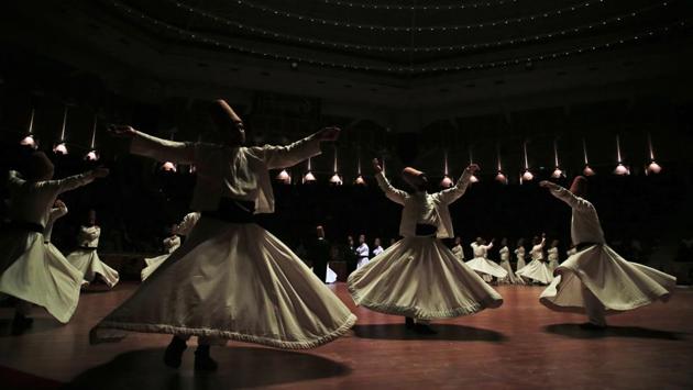 With one hand pointed toward the sky — or heaven and God — and the other toward the ground — or earth — the dervishes perform their dance, known as the Sema. They spin repetitively in prayer, chanting and gaining in speed, as they seek to lose themselves in a spiritual trance that they believe unites them with God. (Lefteris Pitarakis / AP Photo) With one hand pointed toward the sky — or heaven and God — and the other toward the ground — or earth — the dervishes perform their dance, known as the Sema. They spin repetitively in prayer, chanting and gaining in speed, as they seek to lose themselves in a spiritual trance that they believe unites them with God. (Lefteris Pitarakis / AP Photo)