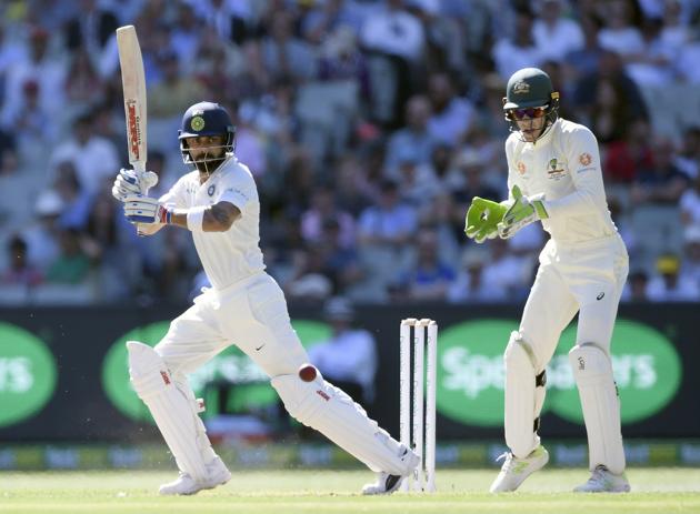 India's Virat Kohli, left and Australia's Tim Paine during play on day one of the third cricket test between India and Australia in Melbourne. (AP)