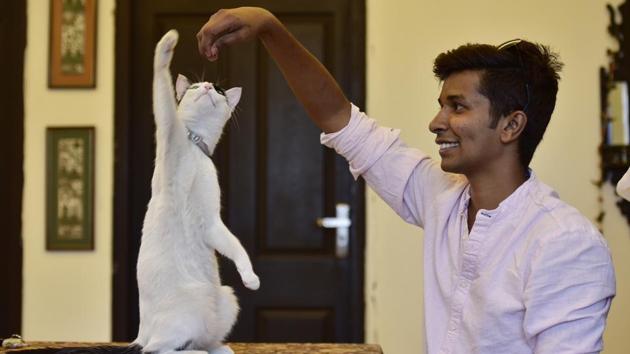 Aaron d’Silva, an animal communicator with a cat at Sector 45, in Noida, Uttar Pradesh. (Virendra Singh Gosain / HT Photo) 