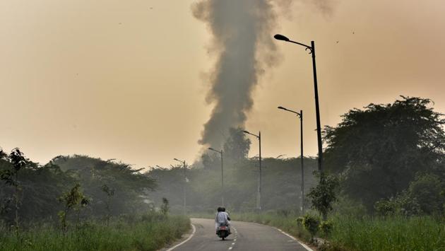 A heap of dry leaves and discarded waste material raises a plume of smoke after catching fire, behind Rajghat, in New Delhi. Despite pre-emptive bans on crackers, stubble burning in neighbouring states and halts on construction activity pollution levels still climbed to hazardous levels as the winter months approached Delhi. (Sonu Mehta / HT Photo) 