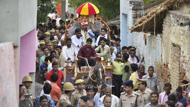 Mounted on a horse carriage, Sanjay Jatav is accompanied by the grooms procession as it passes through Nizampur village to his bride Sheetal’s house at Kasganj near Aligarh, Uttar Pradesh. Jatav’s wedding procession was the first in the village to pass through the traditional ‘upper-caste’ pockets, with pomp and show. (Anushree Fadnavis / HT Photo) 