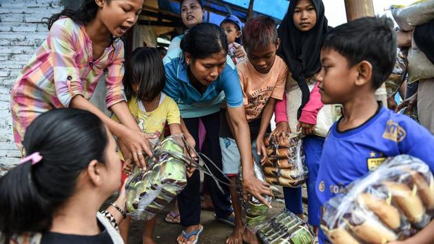 Tsunami-affected children receive food items in Rajabasa in Lampung province. The disaster agency has dispatched helicopters to drop supplies into a handful of hard-to-reach communities along the shattered coastlines. (Mohd Rasfan / AFP) Tsunami-affected children receive food items in Rajabasa in Lampung province. The disaster agency has dispatched helicopters to drop supplies into a handful of hard-to-reach communities along the shattered coastlines. (Mohd Rasfan / AFP)