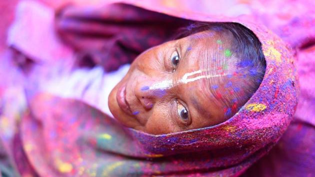 A widow poses for photograph after playing Holi at the historic Gopinath temple in Vrindavan, Uttar Pradesh -- an innitiative by Sulabh International-- for the sixth consecutive year, subverting traditions that otherwise expect them to lead austere and reclusive lives. (Sanchit Khanna / HT Photo) 