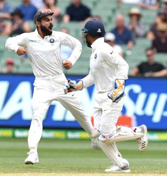 India's captain Virat Kohl (L) and wicketkeeper Rishabh Pant celebrate after the dismissal of Australia's Usman Khawaja on day three of the third test match between Australia and India at the MCG in Melbourne. (REUTERS)