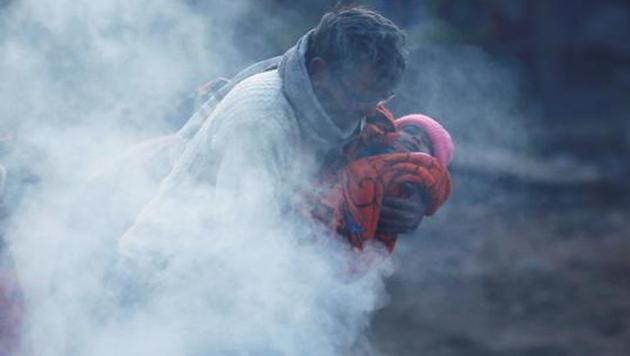 A man holding a baby wrapped in a blanket stands next to a bonfire on a cold winter morning in New Delhi, India, December 19, 2018. REUTERS/Adnan Abidi TPX IMAGES OF THE DAY(REUTERS) A man holding a baby wrapped in a blanket stands next to a bonfire on a cold winter morning in New Delhi, India, December 19, 2018. REUTERS/Adnan Abidi TPX IMAGES OF THE DAY(REUTERS)