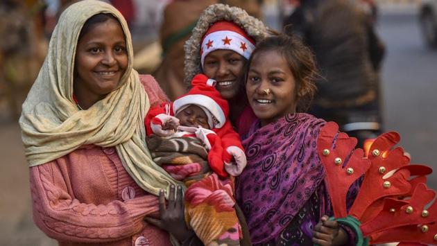 Girls carry a child dressed as Santa Claus outside the Sacred Heart Cathedral on the eve of Christmas Day in New Delhi. (Manvender Vashist / PTI) Girls carry a child dressed as Santa Claus outside the Sacred Heart Cathedral on the eve of Christmas Day in New Delhi. (Manvender Vashist / PTI)