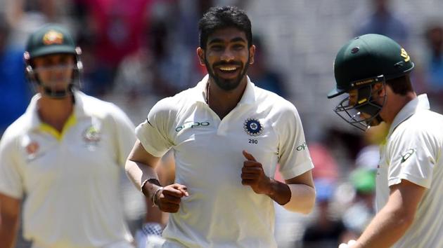 Australia's batsman Travis Head (R) walks off the field as India's paceman Jasprit Bumrah (C) celebrates his dismissal during day three of the third cricket Test match between Australia and India in Melbourne.(AFP)