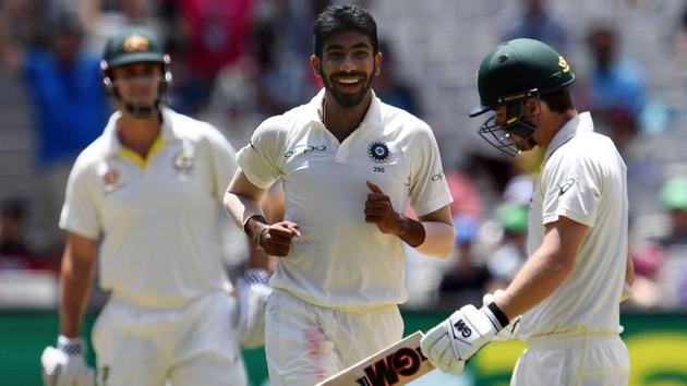 Australia's batsman Travis Head (R) walks off the field as India's paceman Jasprit Bumrah (C) celebrates his dismissal.(AFP)