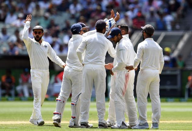 Indian cricketers celebrate the dismissal of Australia's batsman Pat Cummins during day three of the third cricket Test match between Australia and India in Melbourne. (AFP)