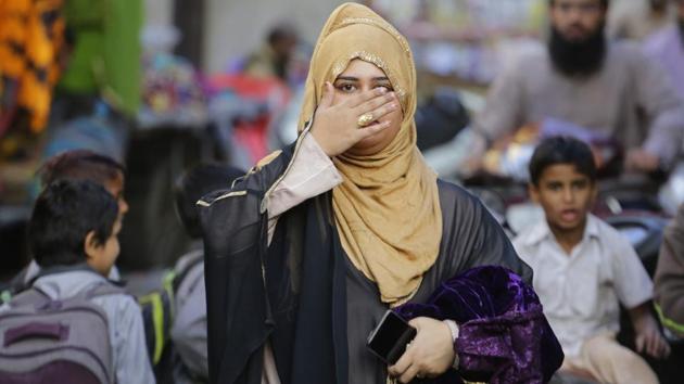A Muslim woman covers her face with hand as she walks through a busy market in Ahmadabad, Gujarat. The Lower House of Parliament on Thursday approved a bill to implement the Supreme Court’s ruling that found the Muslim practice of instant divorce was unconstitutional. (Ajit Solanki / AP) A Muslim woman covers her face with hand as she walks through a busy market in Ahmadabad, Gujarat. The Lower House of Parliament on Thursday approved a bill to implement the Supreme Court’s ruling that found the Muslim practice of instant divorce was unconstitutional. (Ajit Solanki / AP)
