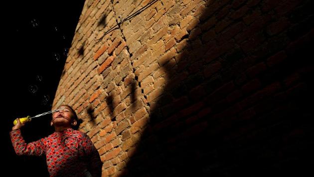 Light illuminates a girl as she blows bubbles along an alley in Lalitpur, Nepal. (Navesh Chitrakar / REUTERS) Light illuminates a girl as she blows bubbles along an alley in Lalitpur, Nepal. (Navesh Chitrakar / REUTERS)