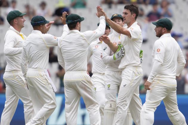 The Australian Cricket team celebrates with bowler Pat Cummins, 2nd right, after he got a wicket during play on day three of the third cricket test between India and Australia in Melbourne. (AP)