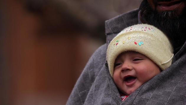 A man carries an infant inside his warm clothes in a village of south Kashmir’s Pulwama district. As per the India Meteorological Department, the temperature in the region will further plummet during the nights. Leh has already recorded minus 17.5 degree and Kargil minus 16.7 degree as the minimum temperature. (Danish Ismail / Reuters) A man carries an infant inside his warm clothes in a village of south Kashmir’s Pulwama district. As per the India Meteorological Department, the temperature in the region will further plummet during the nights. Leh has already recorded minus 17.5 degree and Kargil minus 16.7 degree as the minimum temperature. (Danish Ismail / Reuters)