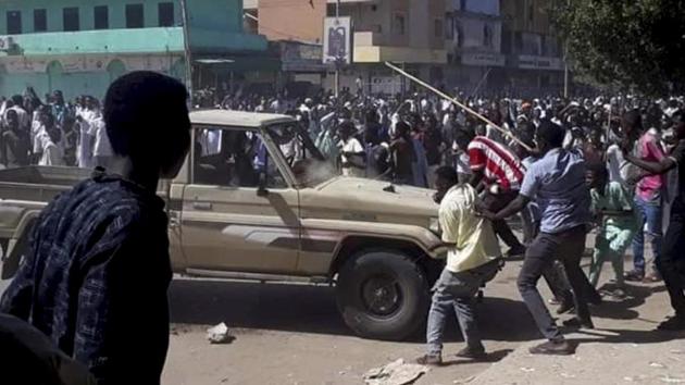 A Sudanese activist, people chant slogans and attack a national security vehicle during a protest, in Kordofan, Sudan. The protest was the latest in a series of anti-government protests across Sudan, initially sparked by rising prices and shortages.(AP)