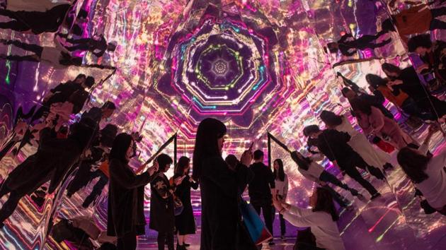 People stand inside a kaleidoscope installation, erected as part of Christmas festivities, at a shopping arcade in Hong Kong. (Philip Fong / AFP) People stand inside a kaleidoscope installation, erected as part of Christmas festivities, at a shopping arcade in Hong Kong. (Philip Fong / AFP)
