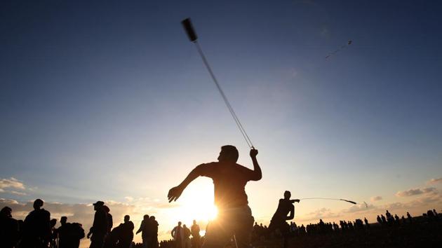 Palestinian protesters use slingshots to hurl stones during a demonstration near the border between Israel and Khan Yunis in the southern Gaza Strip. (Said Khatib / AFP) Palestinian protesters use slingshots to hurl stones during a demonstration near the border between Israel and Khan Yunis in the southern Gaza Strip. (Said Khatib / AFP)