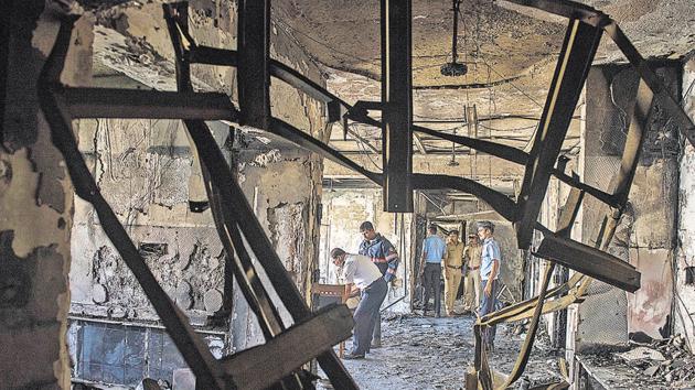Police investigating the flat where the fire broke out on Thursday evening. (Satish Bate/HT Photo) Police investigating the flat where the fire broke out on Thursday evening. (Satish Bate/HT Photo)