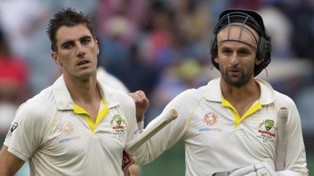 Australia's Pat Cummins, left, and Nathan Lyon walk off the field at the end of play during play on day four of the third cricket test between India and Australia in Melbourne.(AP)