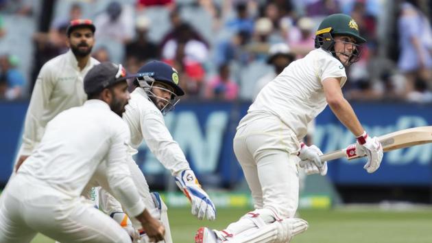 Australia's Pat Cummins, right, sets off for a run during play on day four of the third cricket test between India and Australia in Melbourne. (AP)