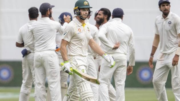 Australia's captain Tim Paine, center, walks off after being caught out during play on day four of the third cricket test between India and Australia in Melbourne. (AP)