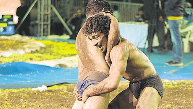 Rahul (right) from Jharkhand in action against Harvinder Singh from Punjab during the first traditional wrestling national championship at Somatane Phata, Talegaon, on Saturday.(Milind Saurkar/HT Photo)