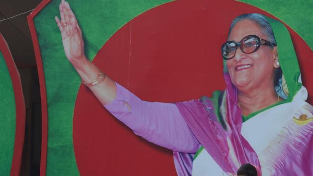 A Bangladeshi man walks past a photo of Prime Minister Sheikh Hasina, in Dhaka on December 29, 2018.(AFP)