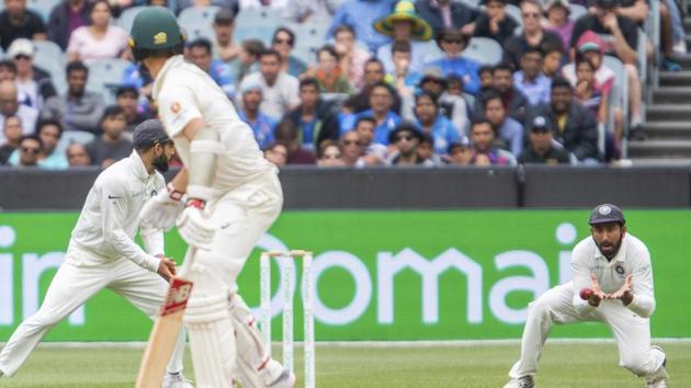 India's Cheteshwar Pujara catches out Australia's Pat Cummins during play on day five of the third cricket test between India and Australia in Melbourne. (AP) India's Cheteshwar Pujara catches out Australia's Pat Cummins during play on day five of the third cricket test between India and Australia in Melbourne. (AP)