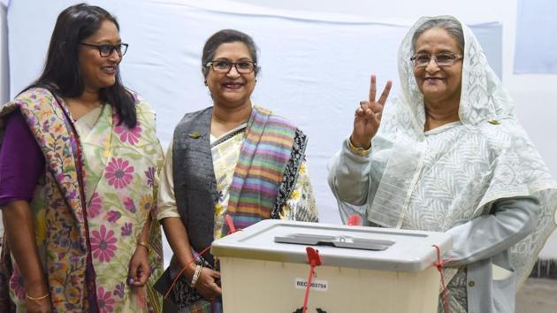 Bangladeshi Prime Minister Sheikh Hasina (R) flashes the victory symbol after casting her vote, as her daughter Saima Wazed Hossain (1st L) and her sister Sheikh Rehana (2nd L) look on at a polling station in Dhaka .(AFP Photo)