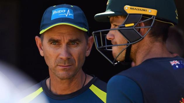 Justin Langer (L) and captain Tim Paine (R) chat during training in Melbourne.(AFP)