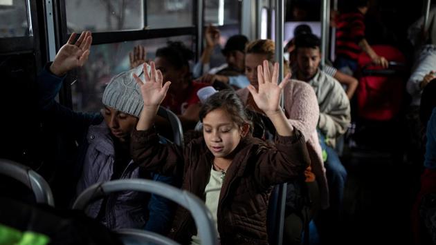 Migrants, part of a caravan of thousands from Central America travelling to the US, raise their hands while praying before moving by buses to a new shelter, in Tijuana, Mexico. Several ‘caravans’ of mostly Honduran migrants who made the trek this year faced arduous conditions, braving fierce heat by day and searching for a safe place to sleep at night. (Alkis Konstantinidis / Reuters) Migrants, part of a caravan of thousands from Central America travelling to the US, raise their hands while praying before moving by buses to a new shelter, in Tijuana, Mexico. Several ‘caravans’ of mostly Honduran migrants who made the trek this year faced arduous conditions, braving fierce heat by day and searching for a safe place to sleep at night. (Alkis Konstantinidis / Reuters)